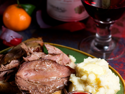 Lakeside-Living_Manitowish-Waters-WI_How-to-Show-Your-Loved-Ones-You-Care-This-Holiday-Season_Holiday-Meal-of-Meat-and-Mashed-Potatoes-with-Wine-Nearby