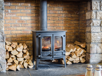 Manitowish Waters WI antique wood burning stove surrounded by stacks of wood