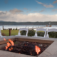 Lakeside-Living_Manitowish-Waters-Wisconsin_Northwoods-Interior-Design-outdoor-fire-table-selection-fire-table-on-a-lake-with-white-event-chairs